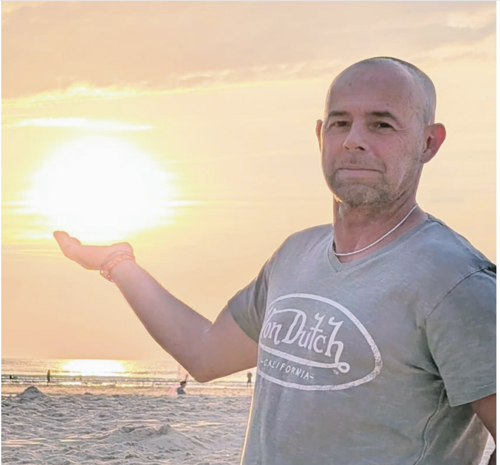 Laurent Germain-Bonne, praticien en hypnose, face au soleil couchant sur la plage